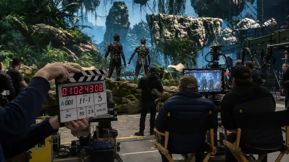 Avatar 3 filming locations and cast updates — motion capture crew on tropical soundstage with clapperboard and director chairs, editorial production reference