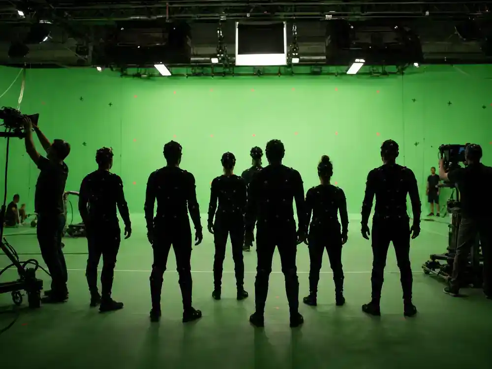 Avatar 3 filming locations and cast updates returning cast — performer silhouettes in motion capture suits from behind on green-screen volume stage