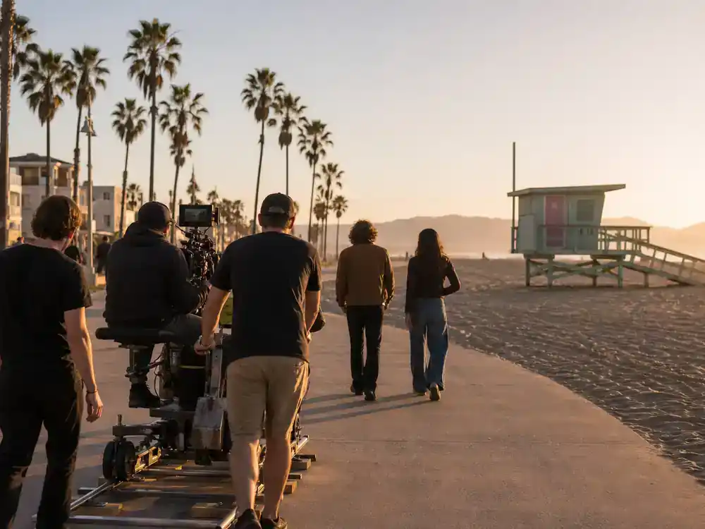 Barbie movie filming locations and set design Venice Beach — California coastal boardwalk location scout with camera dolly crew and actor silhouettes at golden hour