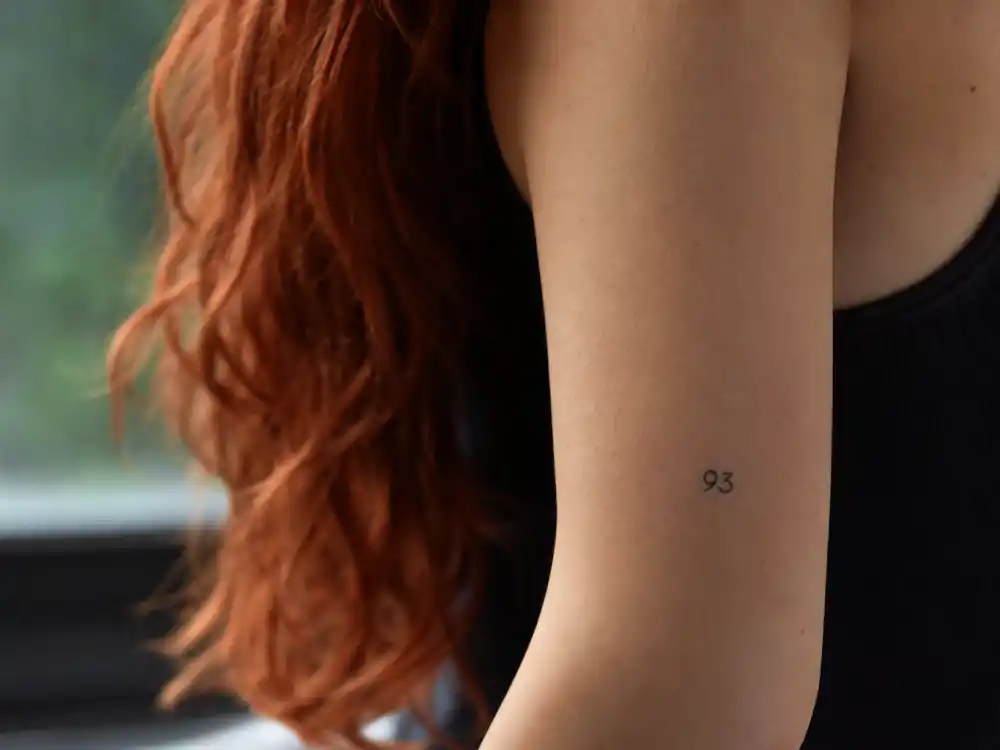 Bella Thorne tattoos and their meanings — 93 finger tattoo honoring birth year 1993 photographed in studio close-up