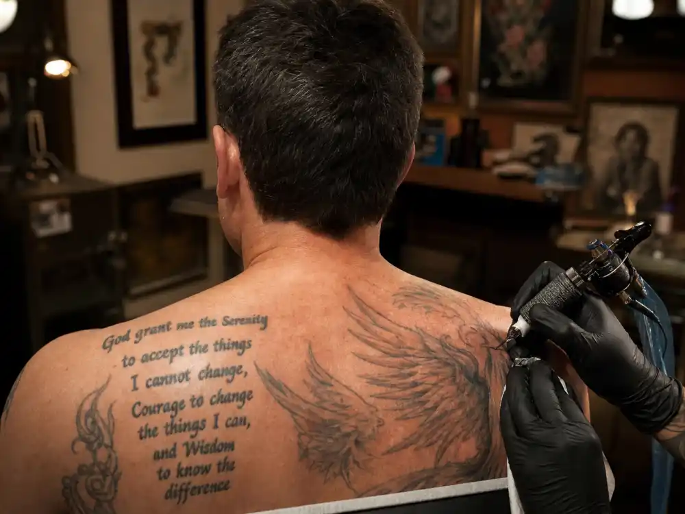 Ben Affleck tattoos and their meanings — tattoo artist session working on phoenix back piece from behind