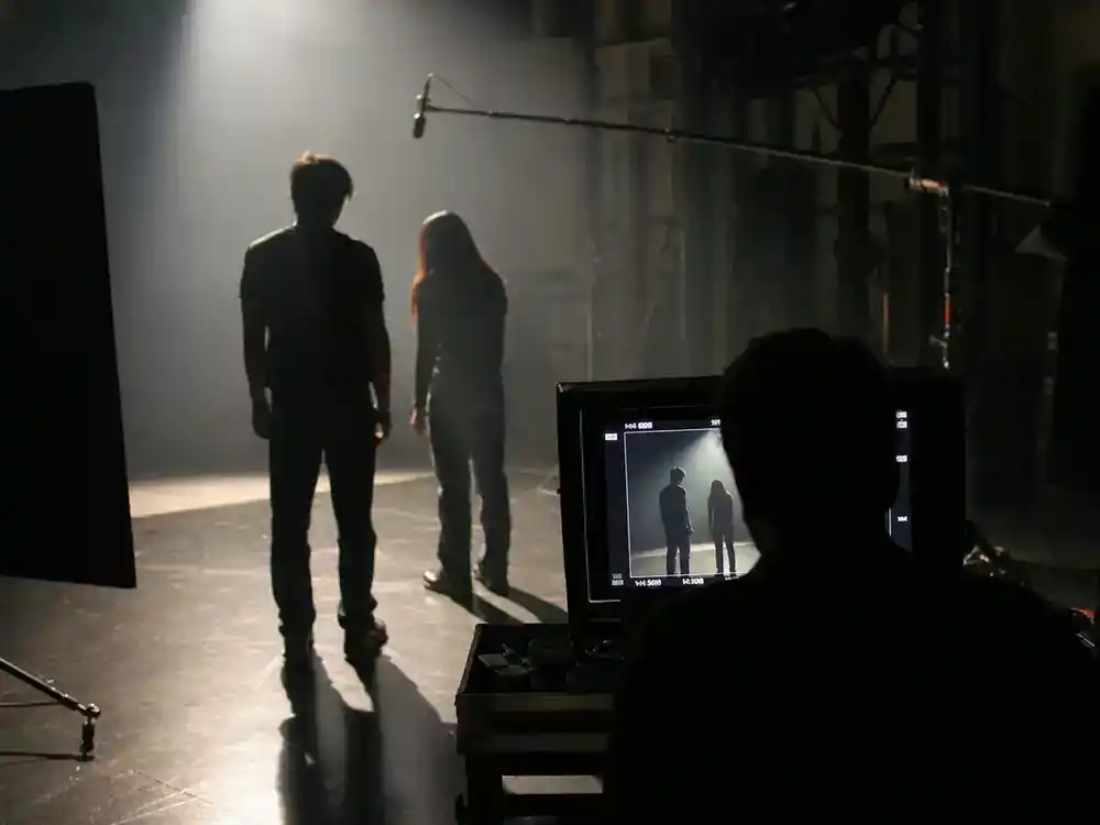 best celebrity performances of 2026 ranked drama leads — actor silhouettes from behind rehearsing on dimly lit soundstage under single spotlight