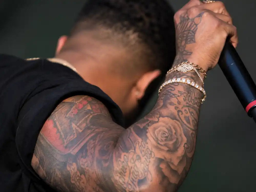 Chris Brown tattoos and their meanings — heavily tattooed forearm sleeve with roses and script on R&B musician arm
