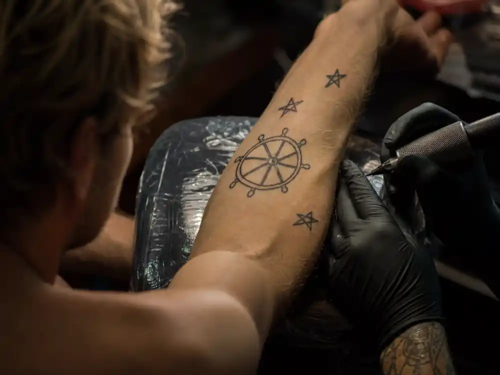 Chris Hemsworth tattoos and their meanings India drawings — left inner forearm dharma wheel and star sketches drawn by daughter in tattoo studio session