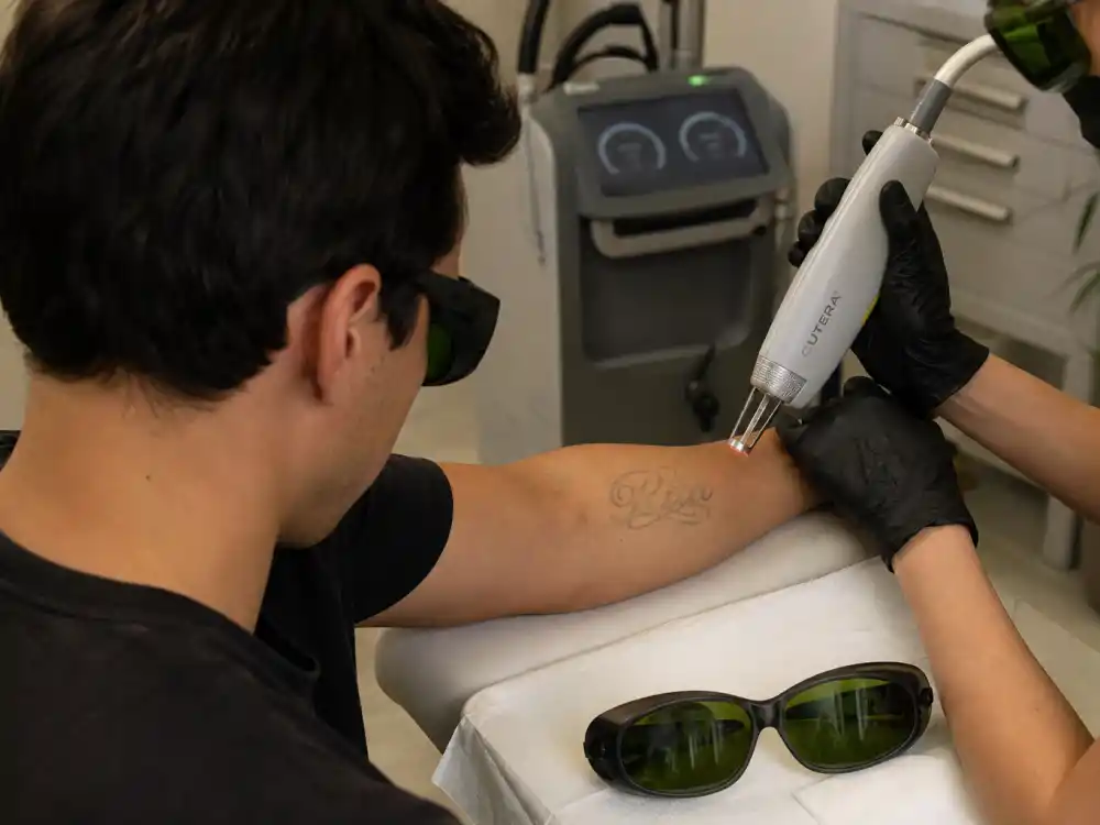 Colin Farrell tattoos and their meanings — laser tattoo removal session on fading forearm ink in clinic