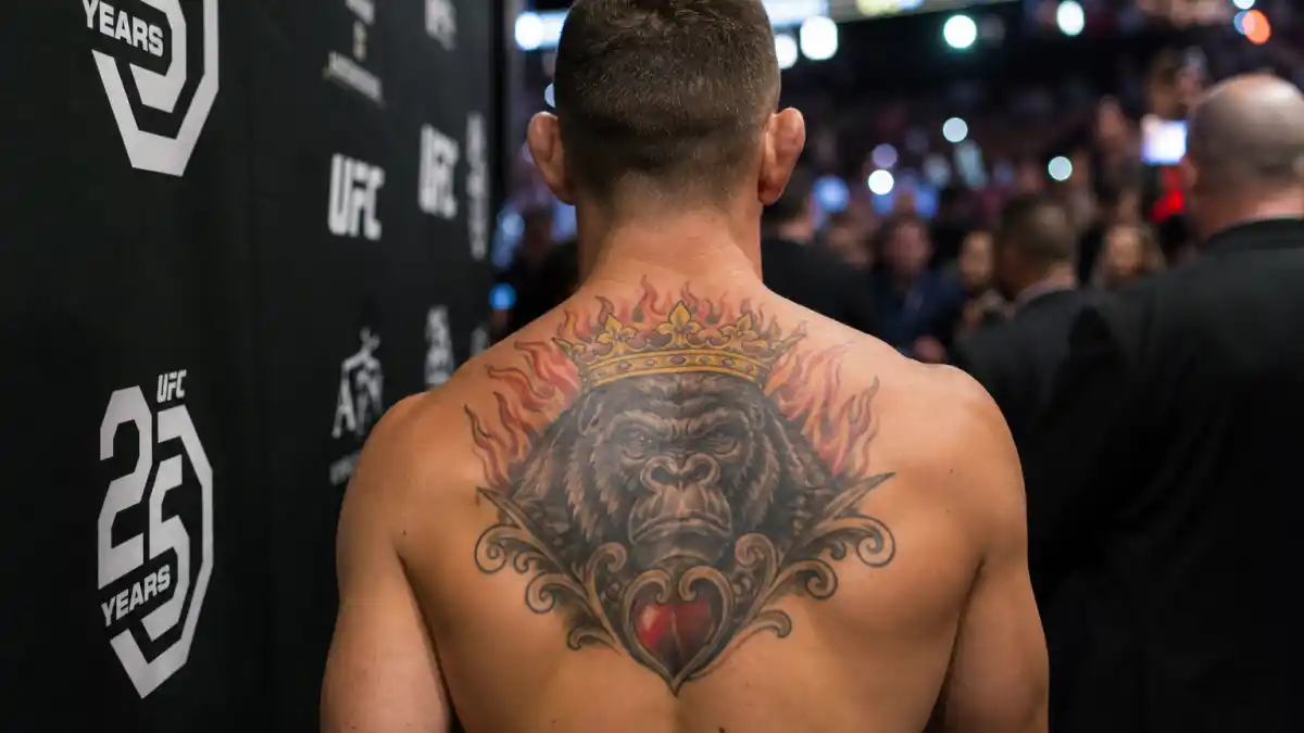 Conor McGregor tattoos and their meanings — Irish UFC star seen from behind in arena tunnel with crowned gorilla chest tattoo and stomach tiger visible
