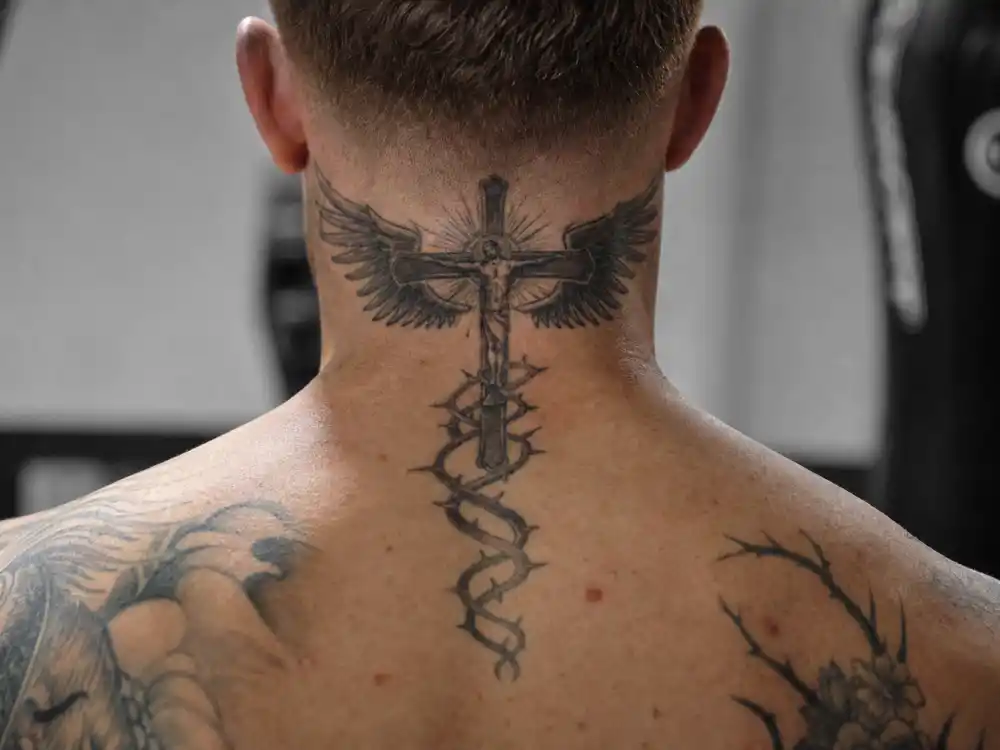 Conor McGregor tattoos and their meanings — winged crucifix neck tattoo and thorn spiral on nape from behind