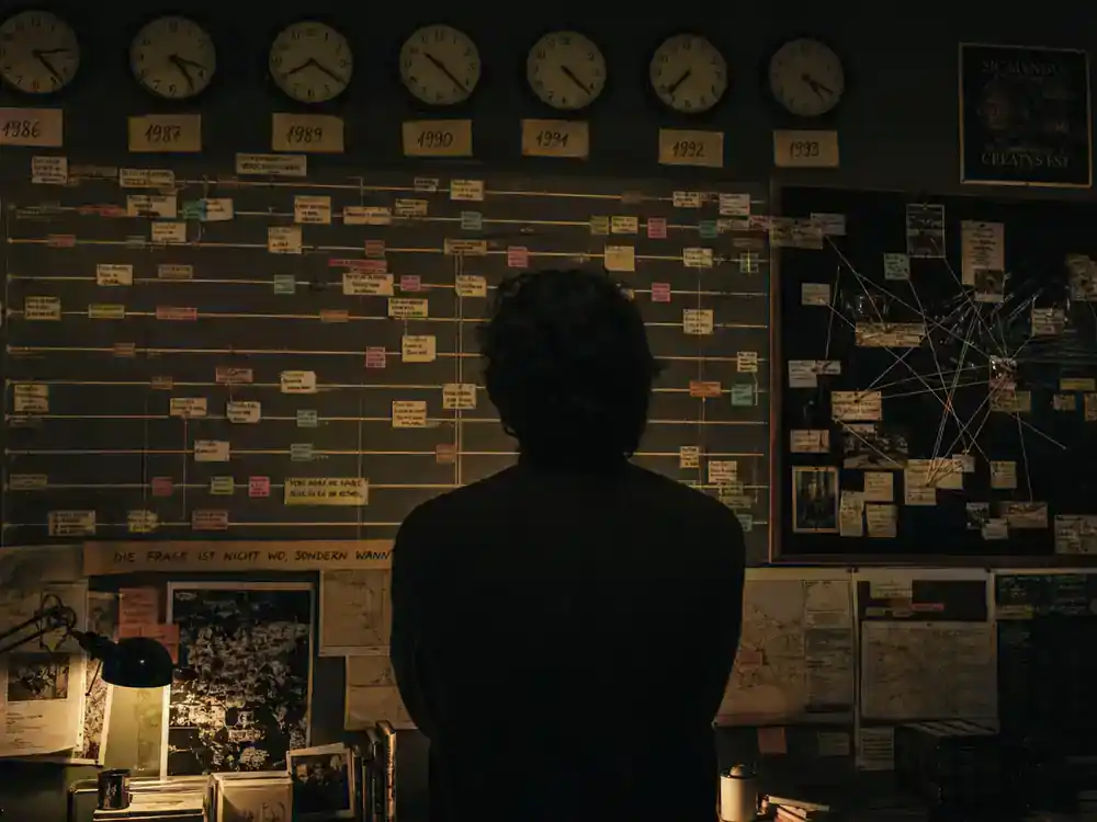 Dark Netflix cast and timeline explained time travel — production art wall with interconnected timeline charts vintage clocks and string boards for German mystery series