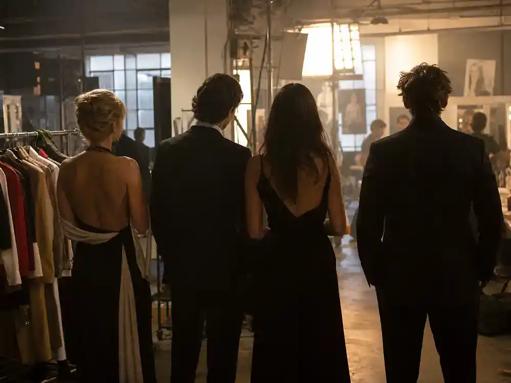 Devil Wears Prada 2 cast release date and plot returning cast — ensemble silhouettes on magazine office film set from behind with wardrobe racks