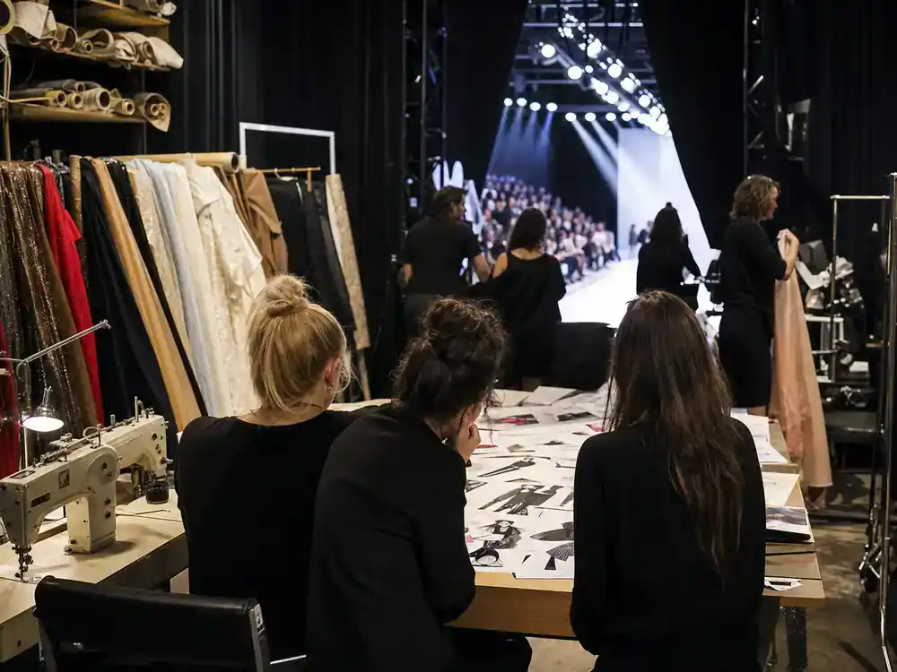 Disney Plus movies and shows July 2026 Project Runway season 22 — fashion TV backstage with sewing machines and runway silhouettes from behind