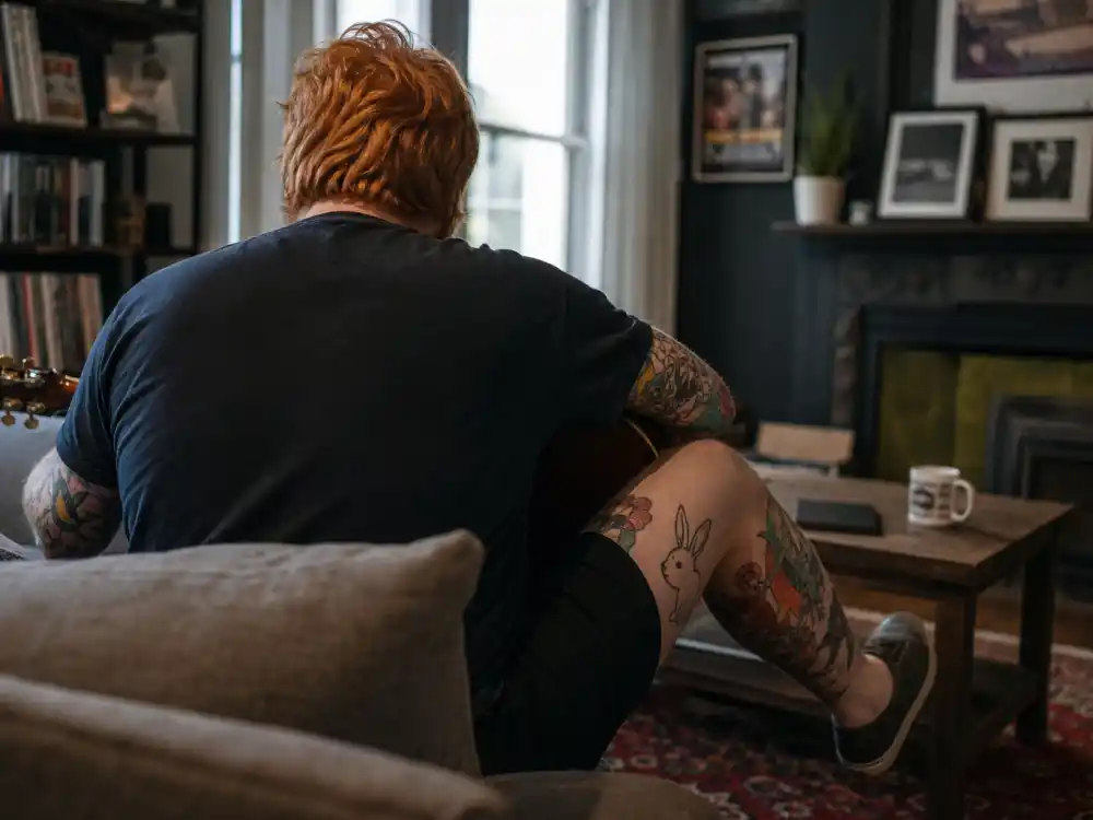 Ed Sheeran tattoos and their meanings leg tattoo — daughter-drawn bunny rabbit child art ink on calf with family drawing book theme