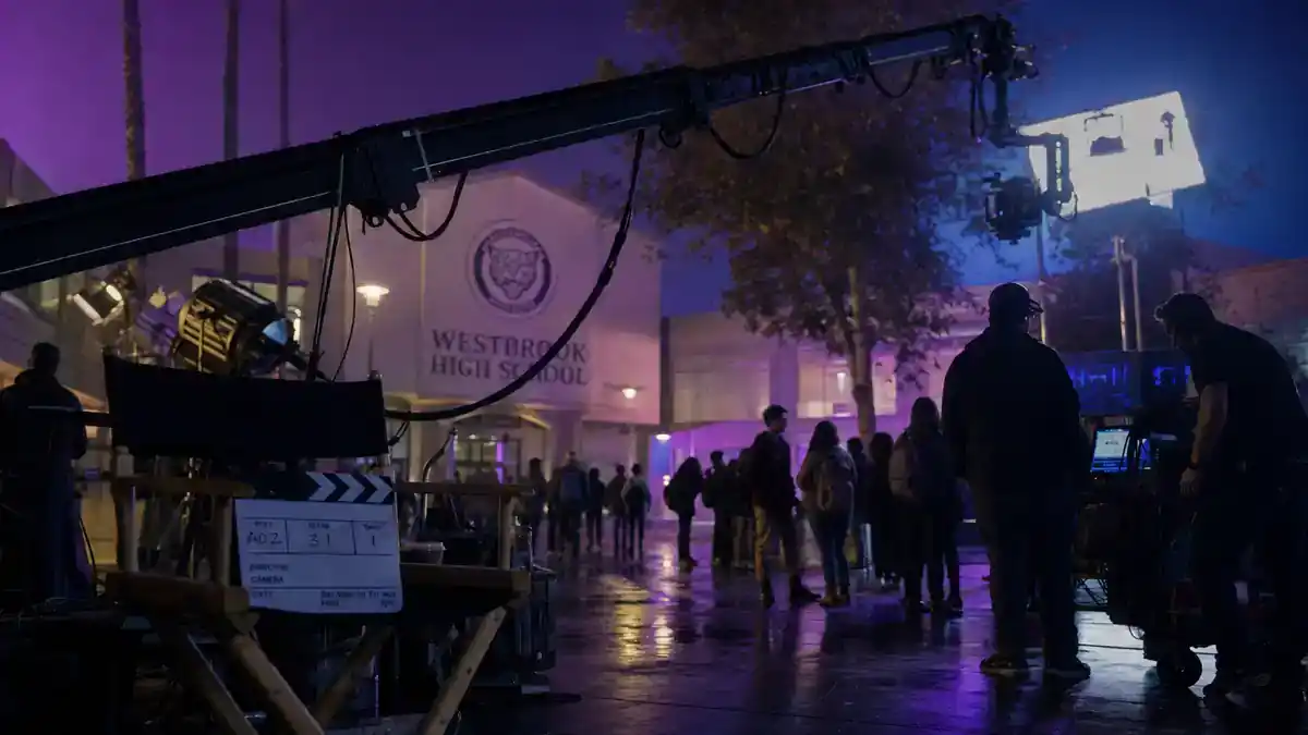 Euphoria season 3 cast and release updates — moody teen TV drama night exterior film set with camera crane clapperboard and crew silhouettes under purple neon