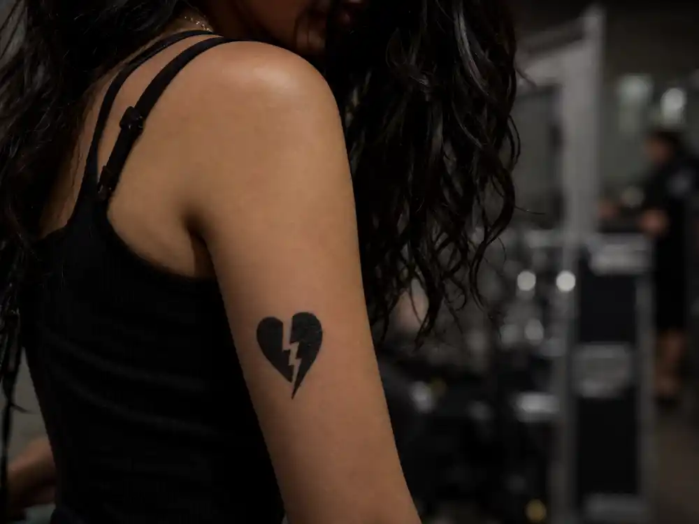 Evan Rachel Wood tattoos and their meanings heart lightning — black heart with lightning bolt music tribute tattoo for Manson and David Bowie
