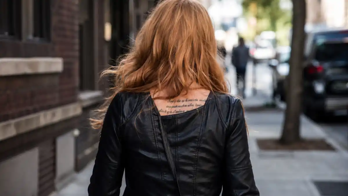Evan Rachel Wood tattoos and their meanings — petite actress with long dark wavy hair from behind at premiere showing upper back Edgar Allan Poe script tattoo