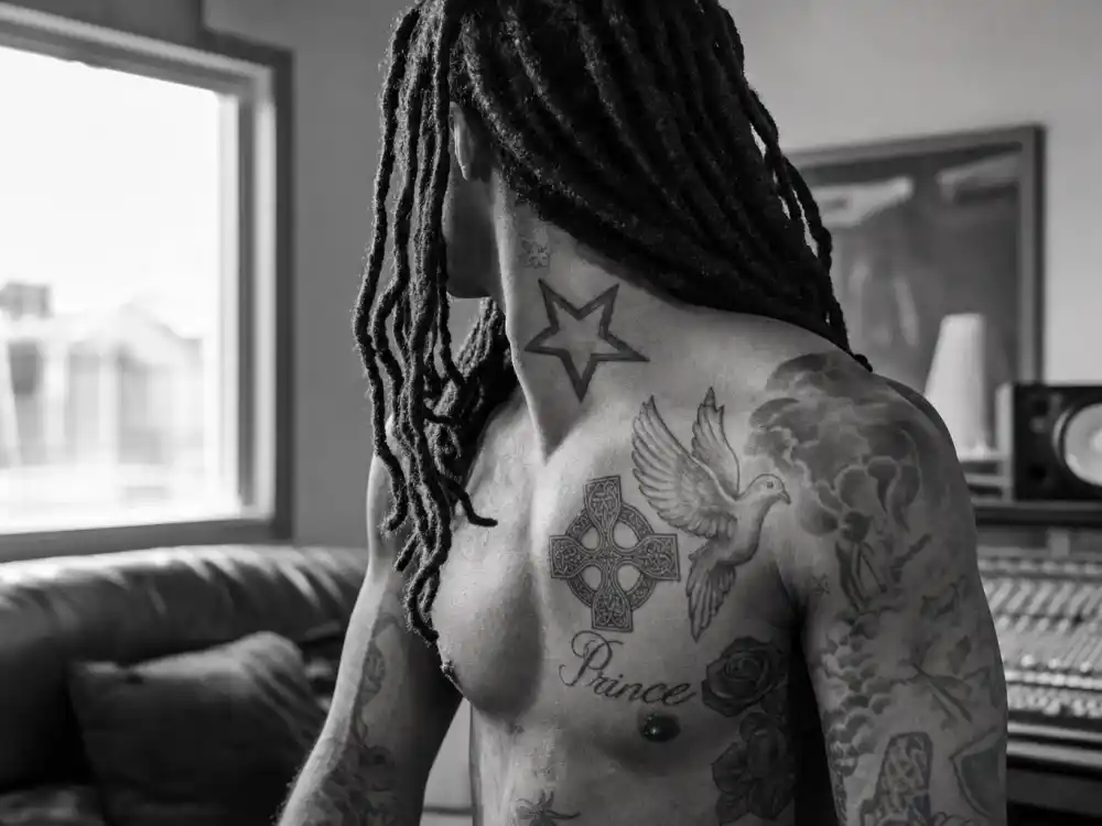 Future tattoos and their meanings — chest dove Celtic cross rose and Prince name tattoos over-shoulder on rapper
