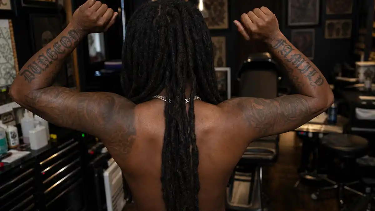 Future tattoos and their meanings — Atlanta rapper seen from behind in tattoo studio with DUNGEON and FAMILY gothic forearm script visible