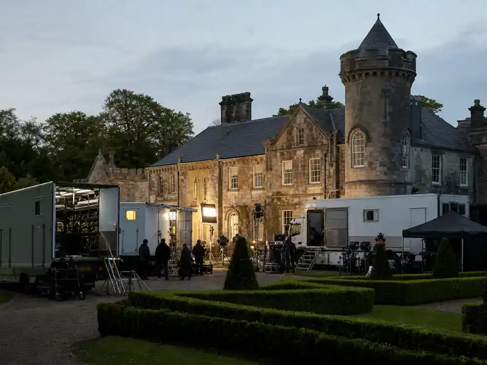 Game of Thrones filming locations in Ireland guide Castle Ward — historic Irish estate manor with stone towers film production trucks and crew on driveway