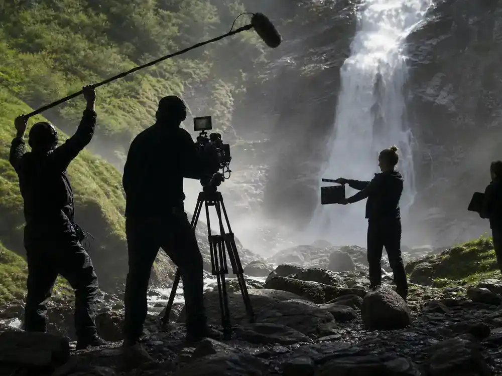 Harry Potter filming locations in Scotland guide Steall Falls — film crew with tripod near Glen Nevis waterfall cascade green gorge production day
