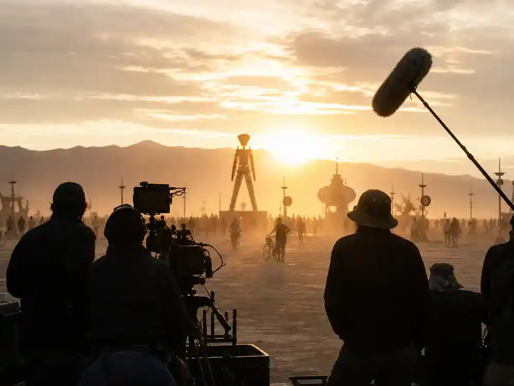 HBO Max new series July 2026 guide The Man Will Burn — documentary crew silhouettes filming desert festival landscape at golden hour