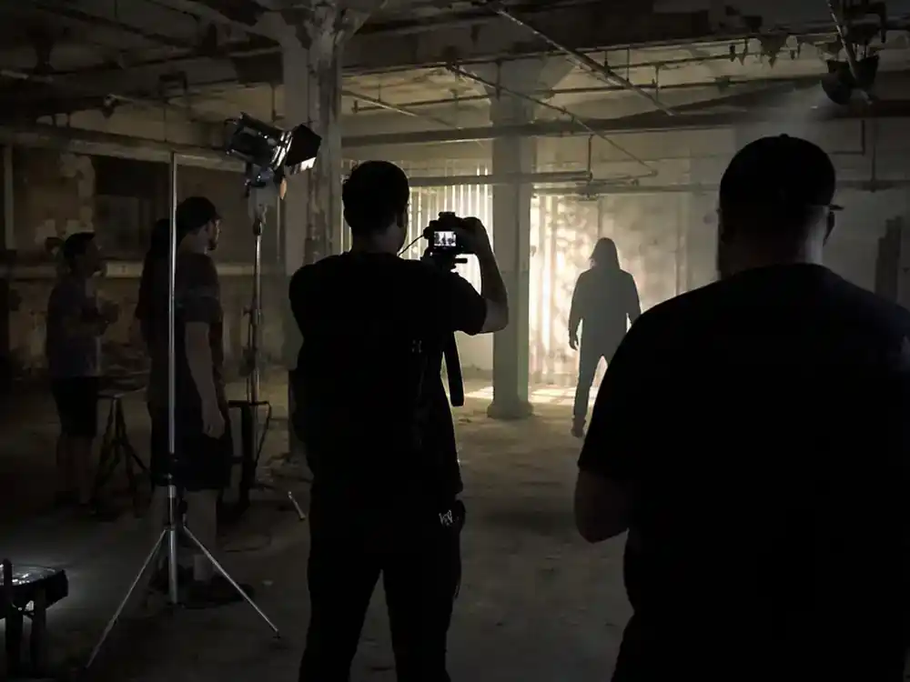 Horror franchise sequels 2026 cast guide indie horror — small crew shooting sequel in abandoned warehouse with handheld camera and actor silhouettes