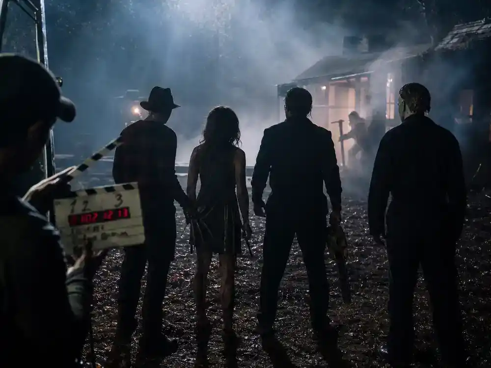 Horror franchise sequels 2026 cast guide Scream sequels — meta slasher cast silhouettes from behind rehearsing on foggy film set with clapperboard