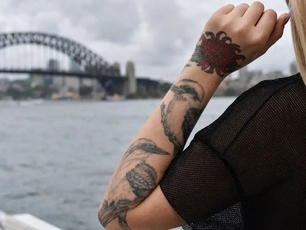 Iggy Azalea tattoos and their meanings Australian roots — waratah state flower hand tattoo and kookaburra bird forearm ink honoring New South Wales heritage
