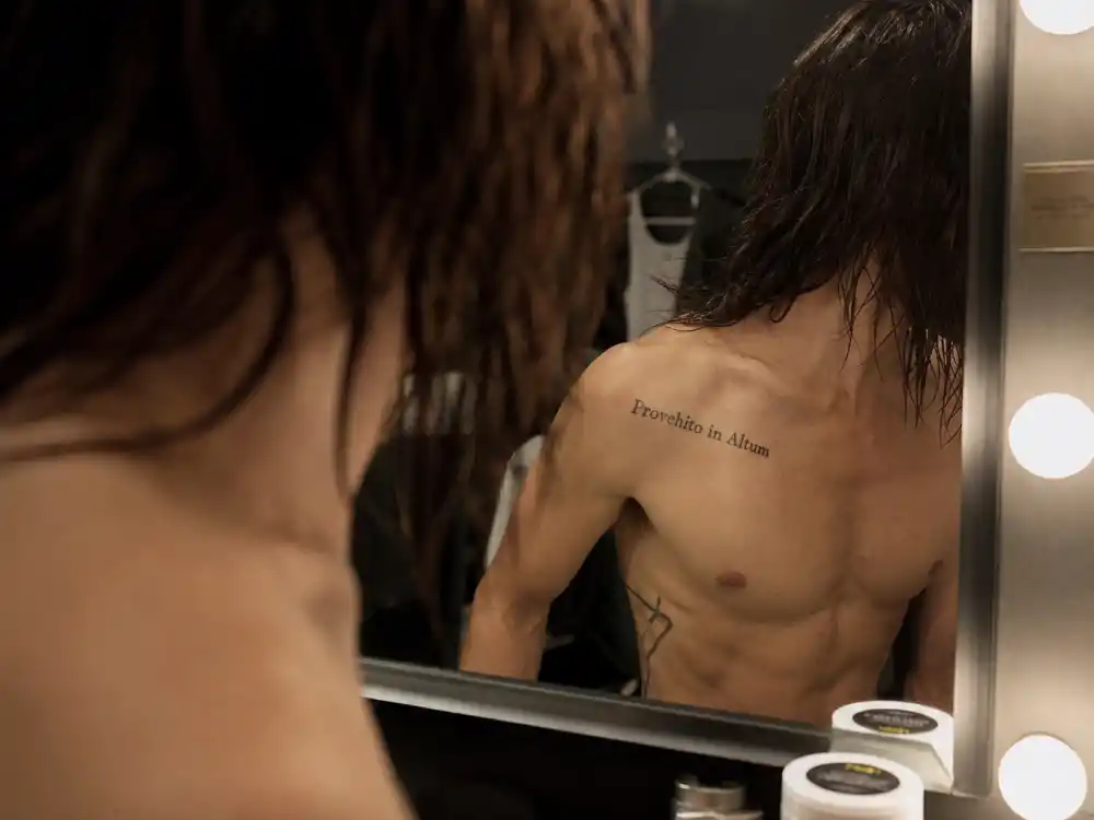 Jared Leto tattoos and their meanings — Provehito in Altum Latin band motto script on right collarbone mirror reflection