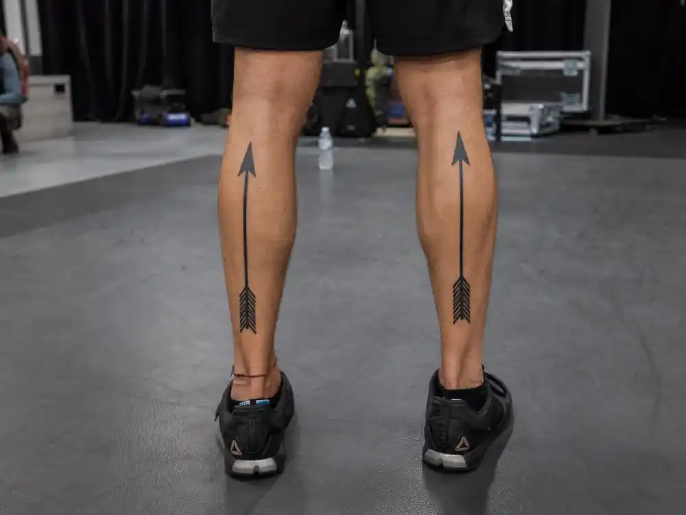 Jared Leto tattoos and their meanings — symmetrical Roman arrow calf tattoos pointing upward on both legs