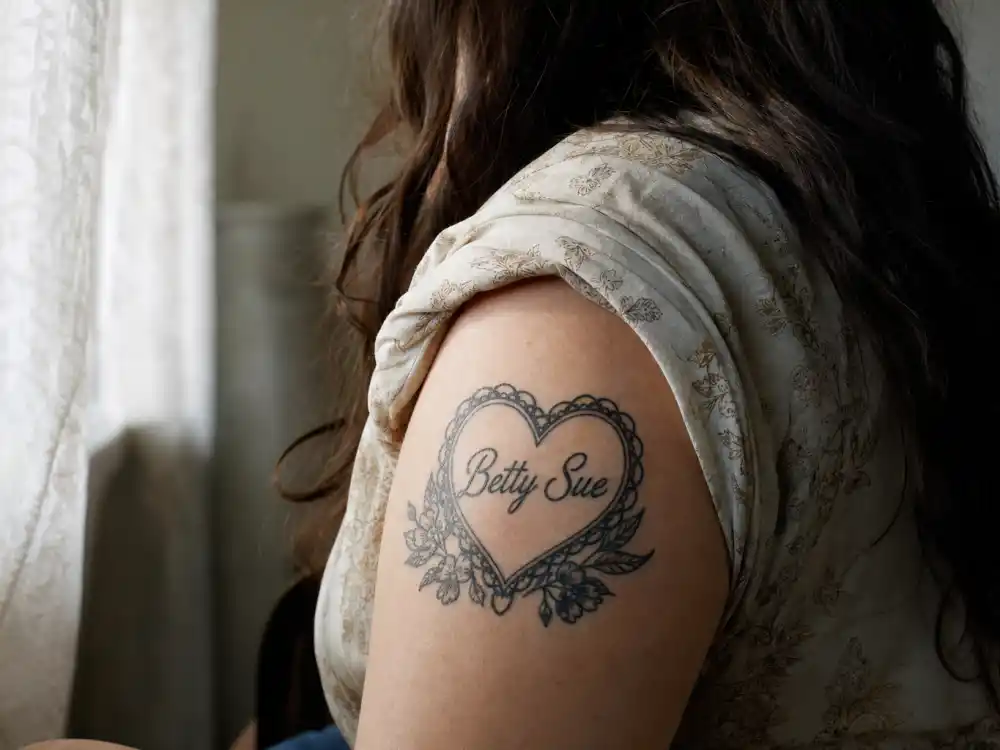 Johnny Depp tattoos and their meanings — Betty Sue heart tattoo tribute to mother on left upper arm over-shoulder view