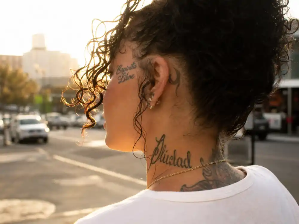 Kehlani tattoos and their meanings — Espiritu script tattoo on forearm photographed in studio mirror from behind