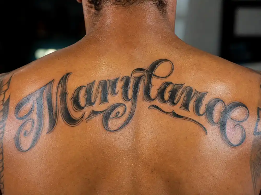 Kevin Durant tattoos and their meanings — Maryland arc script tattoo across upper back shoulder blades close-up