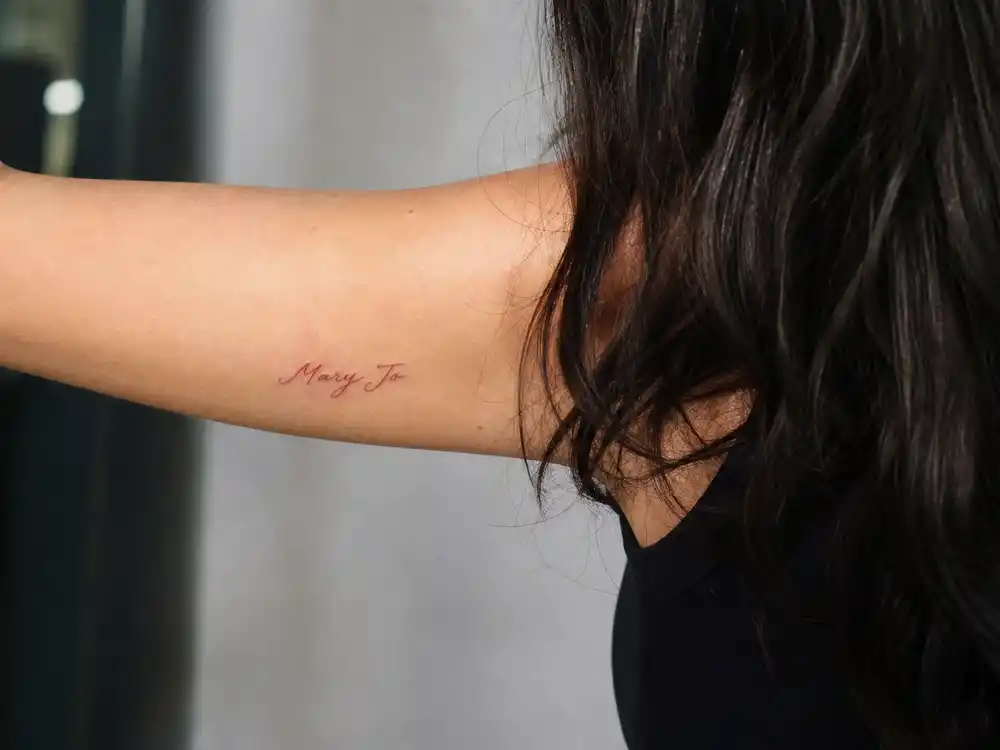 Kylie Jenner tattoos and their meanings — Mary Jo grandmother name tattoo in grandfather handwriting red script on inner arm