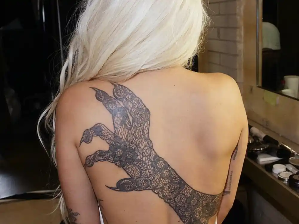 Lady Gaga tattoos and their meanings — monster paw lace tattoo on upper back dedicated to Little Monsters fan community