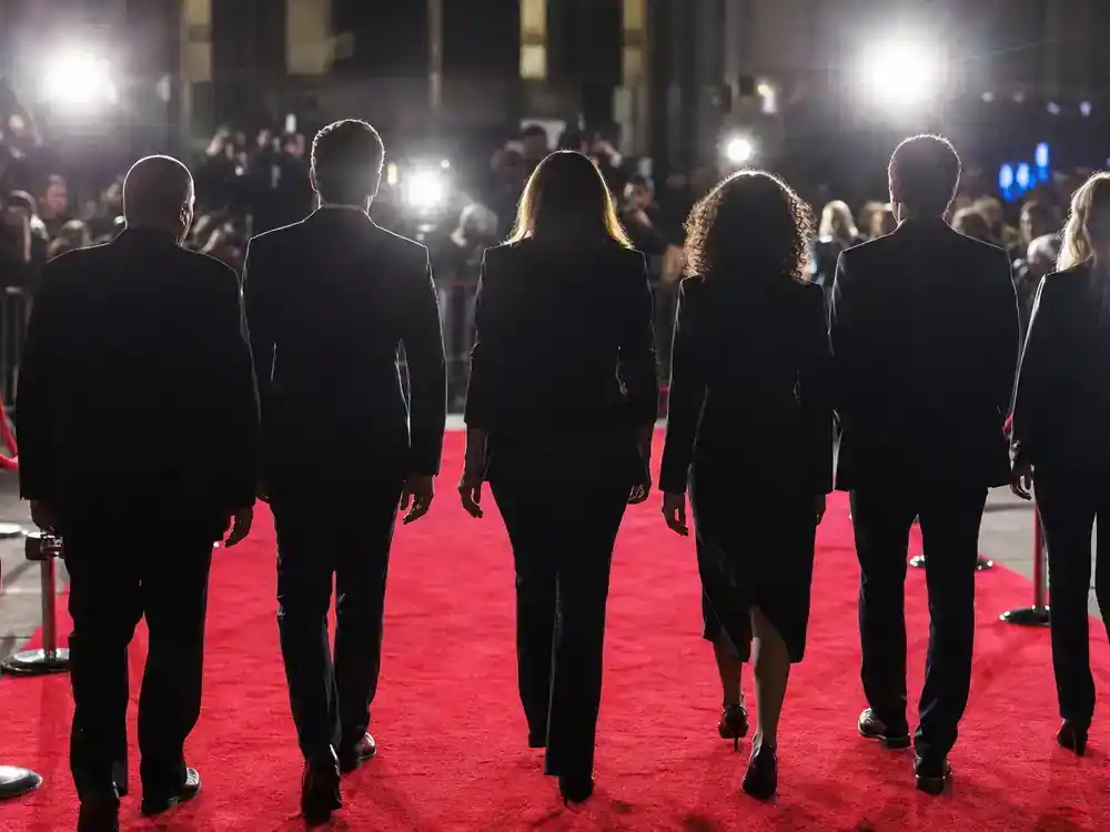 Law and Order SVU season 27 cast guide NBC premiere — cast silhouettes from behind walking toward camera lights on red carpet stanchions at TV premiere night