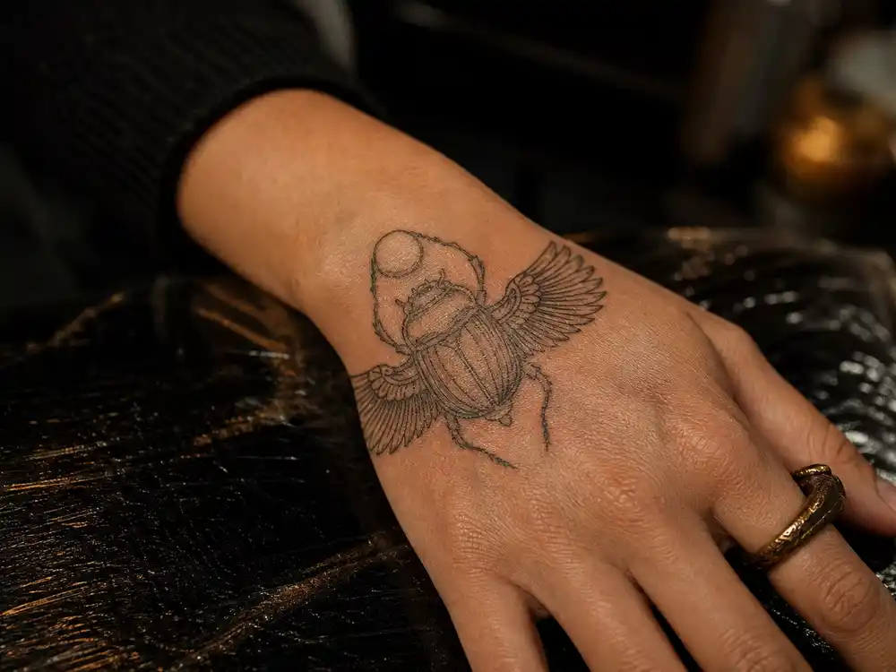 Lena Headey tattoos and their meanings scarab — large beetle tattoo on back of hand eternal life protection ancient Egyptian symbolism