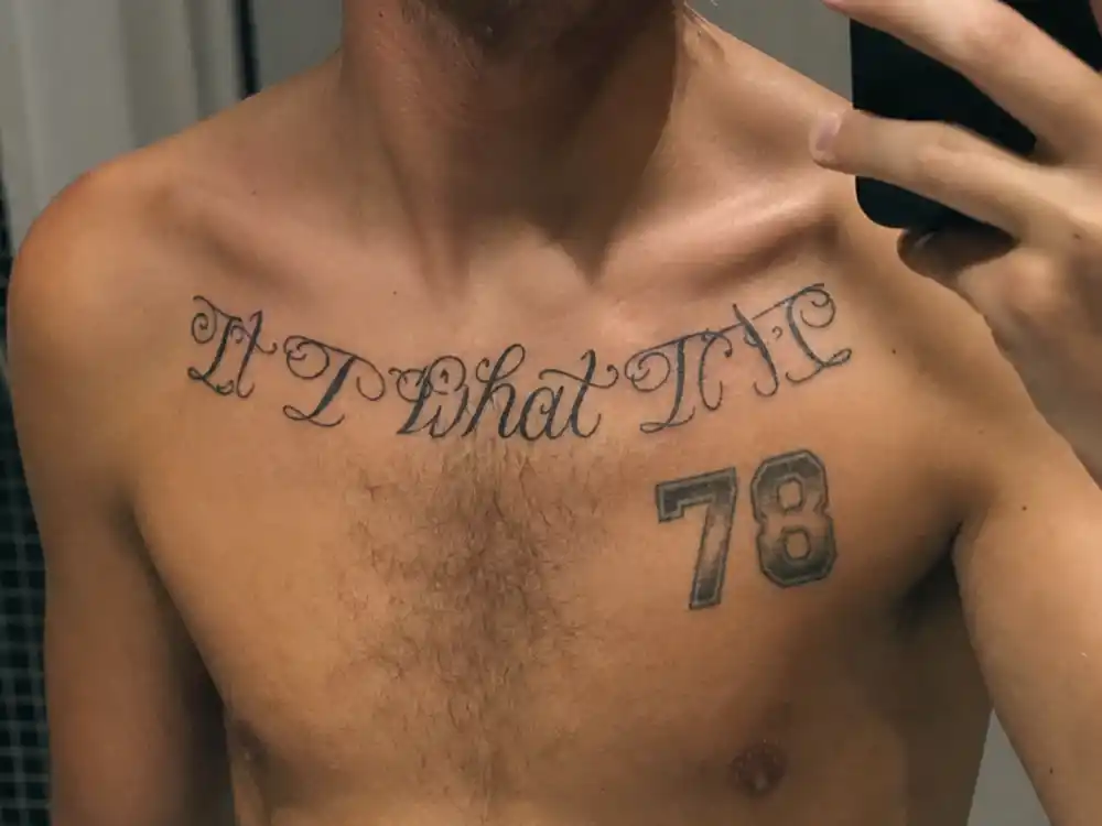 Louis Tomlinson tattoos and their meanings chest script — It is what it is collarbone tattoo and number 78 pec ink mirror close-up