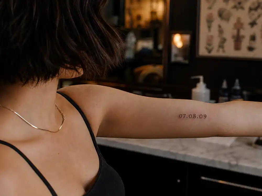 Maisie Williams tattoos and their meanings casting date — peach 07.08.09 inner forearm tattoo marking Game of Thrones casting day with Sophie Turner