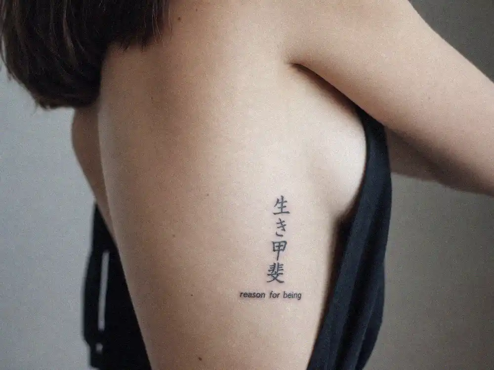 Maisie Williams tattoos and their meanings ikigai — Japanese kanji characters on ribcage meaning reason for being applied by Dr Woo