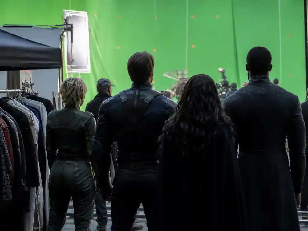 Marvel Avengers cast net worth 2026 ranked core cast — ensemble silhouettes on blockbuster film set from behind with costume racks