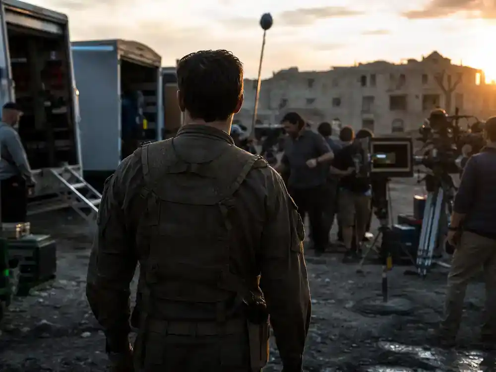 Marvel Cinematic Universe phase 6 movies cast guide Captain America Brave New World — actor silhouette in generic military film costume from behind on outdoor blockbuster location