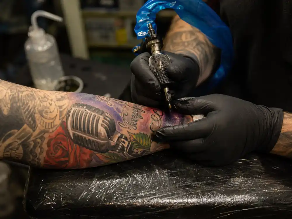 Megan Thee Stallion tattoos and their meanings fan tribute — colorful music-themed forearm tattoo in professional studio session