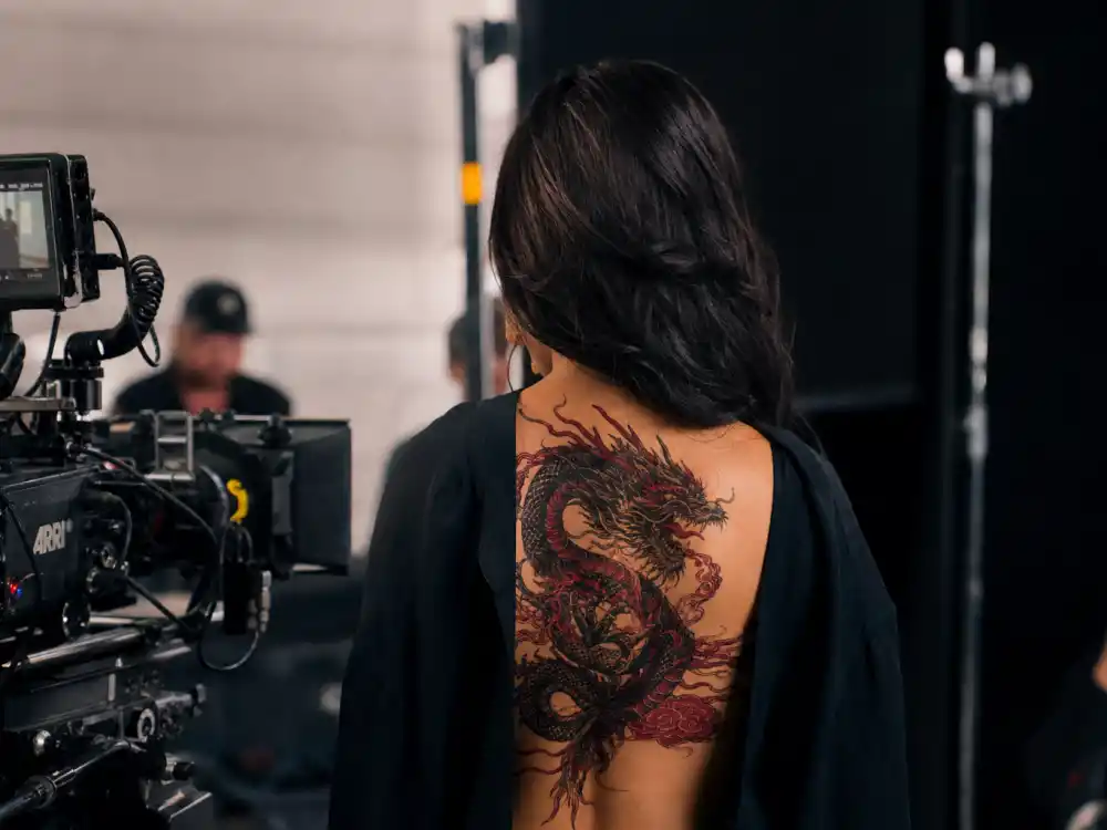Megan Thee Stallion tattoos and their meanings Mamushi — temporary Japanese dragon and cloud back body art applied during Tokyo music video shoot from behind