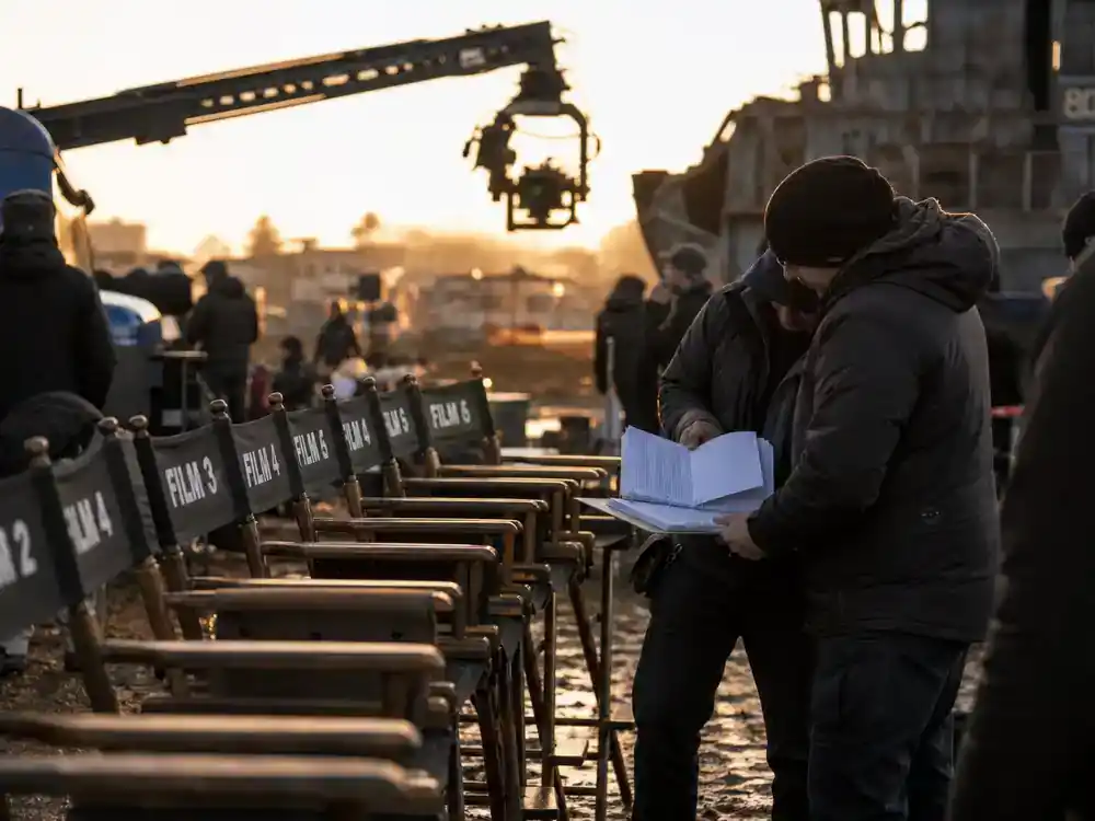 Most anticipated movies of 2026 ranked franchise sequels — numbered director chairs on outdoor film set with crew reviewing scripts, no identifiable faces
