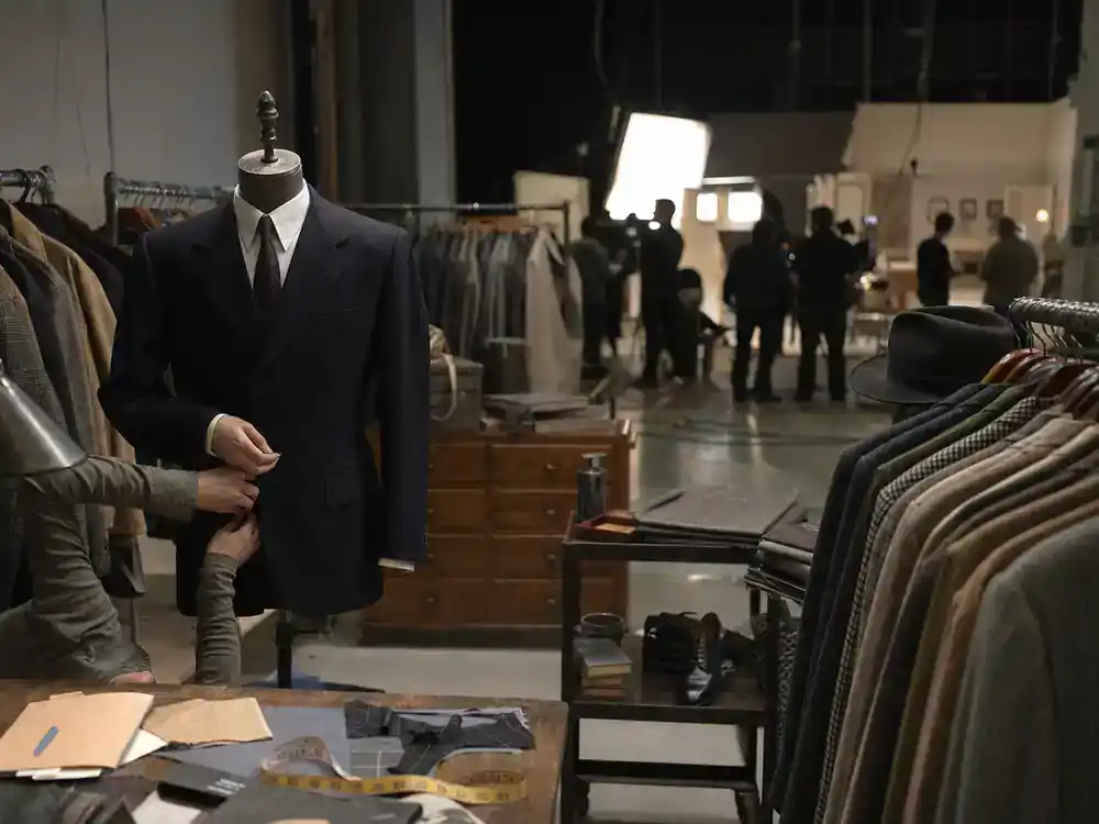 NCIS franchise 2026 cast and spinoff guide Origins prequel — period costume wardrobe department on historical TV drama soundstage with vintage suits on racks