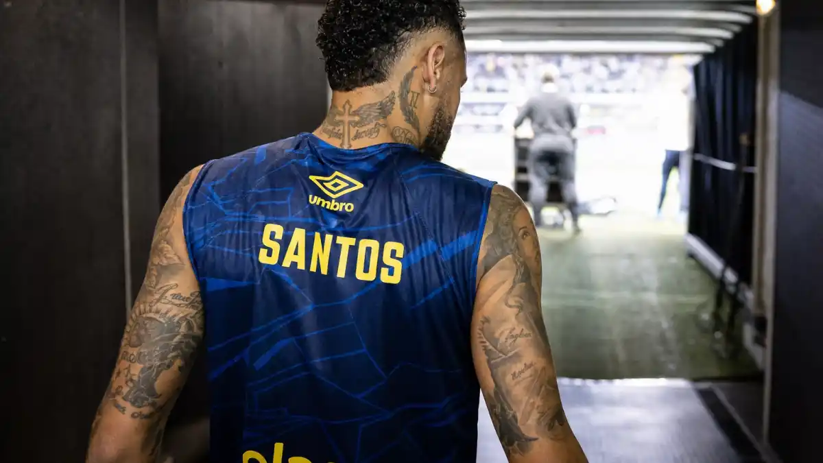 Neymar tattoos and their meanings — Brazilian soccer athlete from behind in stadium tunnel showing extensive arm and neck tattoos
