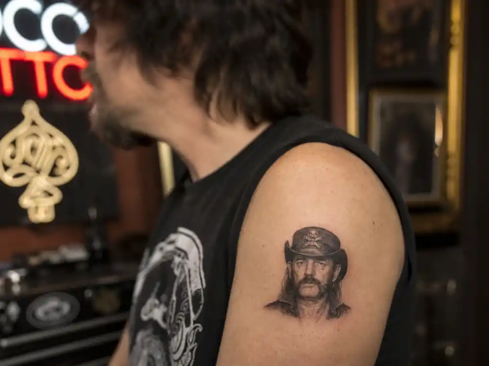 Norman Reedus tattoos and their meanings — small Lemmy Kilmister portrait arm tattoo from New Orleans rush session