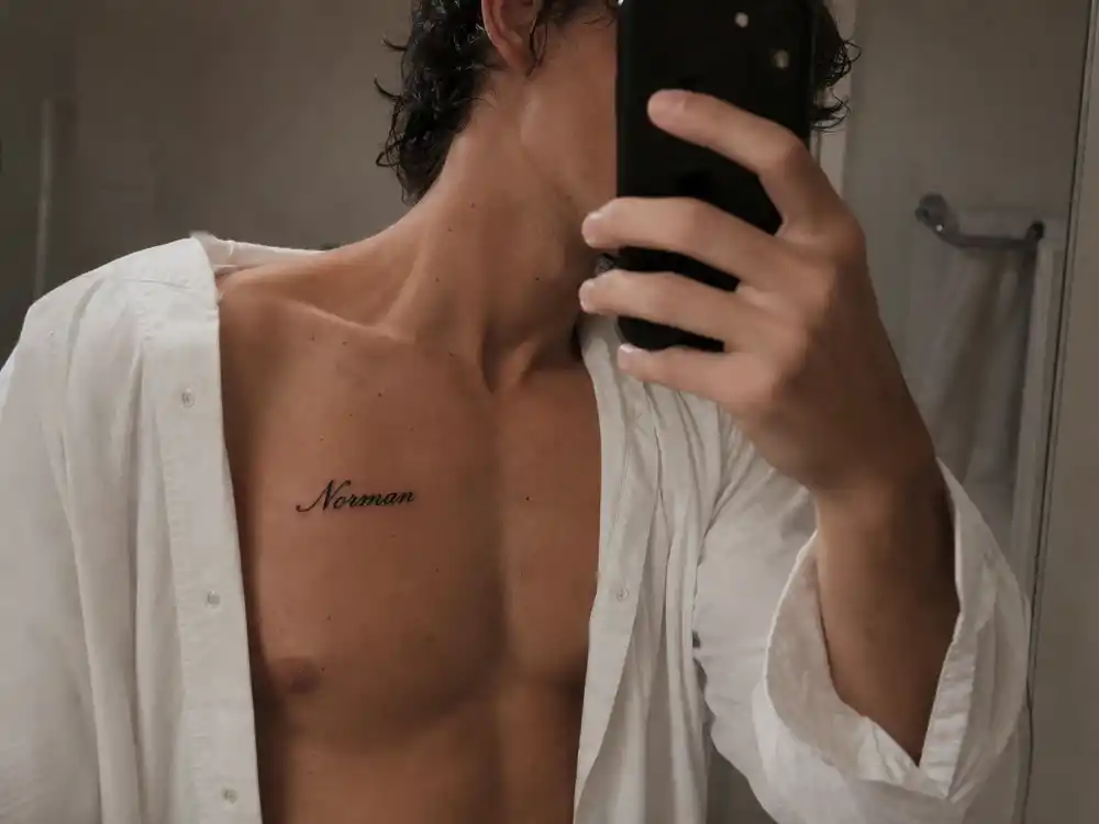Norman Reedus tattoos and their meanings — Norman father name chest tattoo visible in over-shoulder mirror documentation