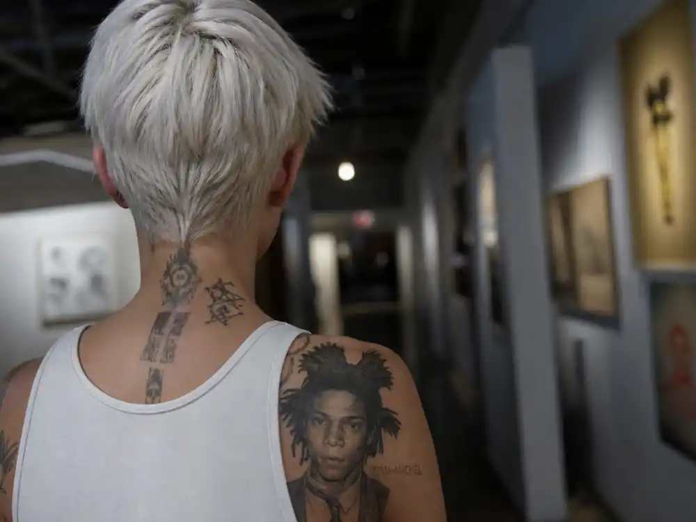 Ruby Rose tattoos and their meanings Basquiat — Jean-Michel Basquiat portrait shoulder tattoo and crown ribcage art tribute