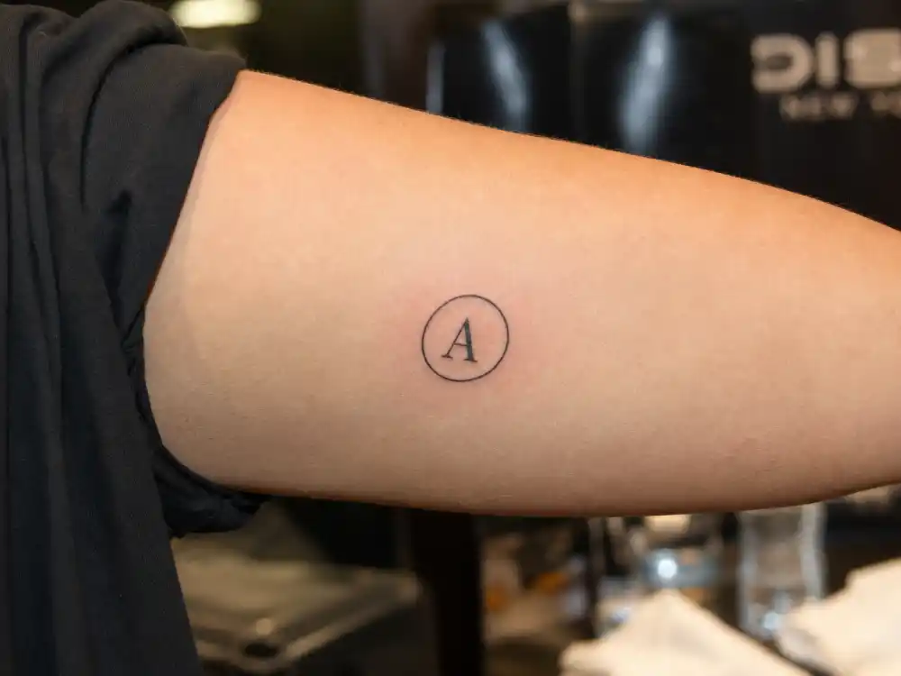 Scarlett Johansson tattoos and their meanings — Avengers logo tattoo on inner right upper arm in backstage close-up