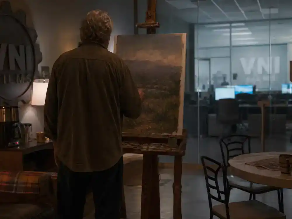 Severance season 2 cast and plot guide John Turturro Irving B — actor silhouette from behind painting at easel on corporate break room film set